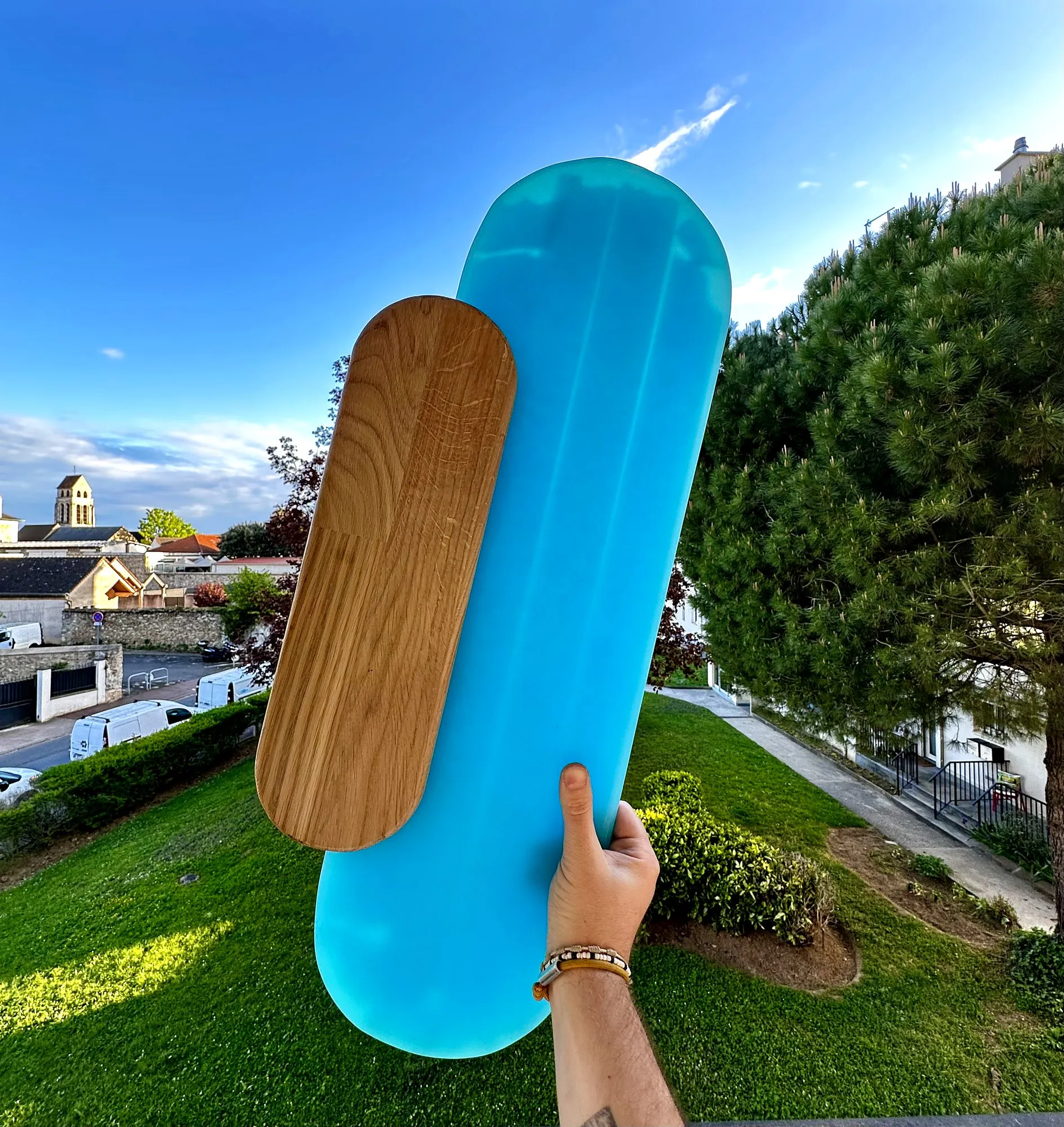 Applique murale tenue en main, vue de face avec le socle en bois
